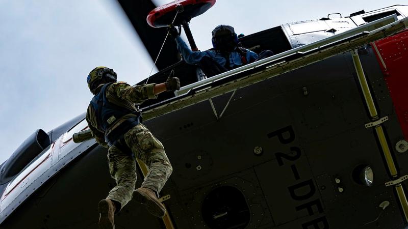 A soldier winches out of a helicopter in a crash rescue exercise in Papua New Guinea.